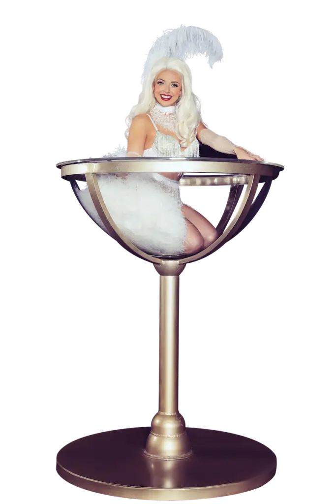 Award-winning and internationally touring showgirl, burlesque, and circus artist Adèle Wolf posing in her giant champagne coupe / martini glass prop.
